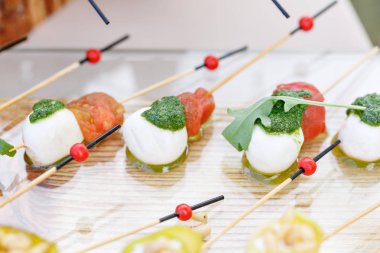 İştah açıcı, Caprese. Kiraz domates, mozzarella ve fesleğen şiş üzerinde. . Pesto sos. Lezzetli büfe masa. Yaz Partisi açık.