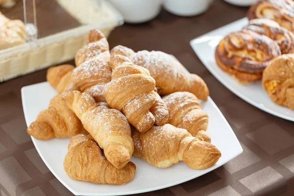 Färska croissanter på vit platta. Franska traditionella bakverk. Frukost i hotel smörgåsbord. — Stockfoto