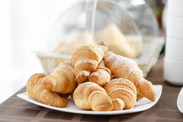 Färska croissanter på vit platta. Franska traditionella bakverk. Frukost i hotel smörgåsbord. — Stockfoto
