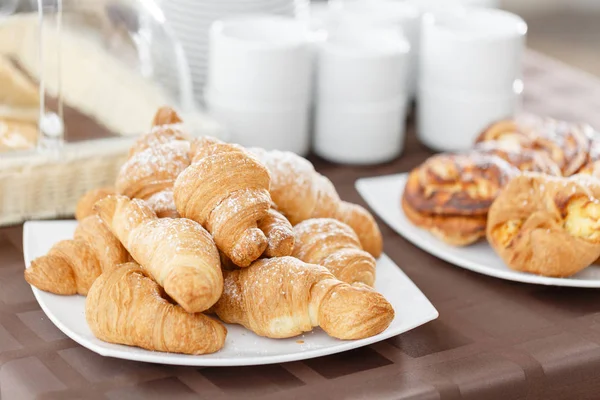 Färska croissanter på vit platta. Franska traditionella bakverk. Frukost i hotel smörgåsbord. — Stockfoto