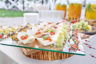 Lezzetli karides ve dilimlenmiş domates ahşap bir tekne. Kabak çam fıstığı ile alır. Lezzetli büfe masa. Yaz Partisi açık. Kavram catering