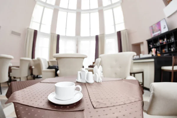 Kaffee weiße Tasse zum Frühstück im Restaurant mit Hotel Hintergrund. Frühstückskonzept — Stockfoto