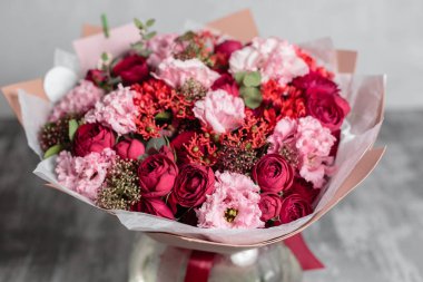 Yakın çekim güzel buket cam vazo içinde sunulan. Gri arka plan bahar çiçekleri. çiçekçi dükkanı