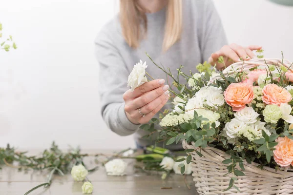 Primer plano manos florista femenina. El taller floral - la mujer que hace la composición hermosa de flores el ramo en la cesta de mimbre. Concepto floristería — Foto de Stock