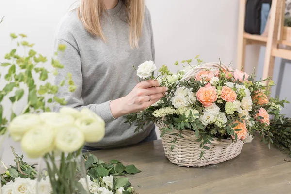 Primer plano manos florista femenina. El taller floral - la mujer que hace la composición hermosa de flores el ramo en la cesta de mimbre. Concepto floristería — Foto de Stock