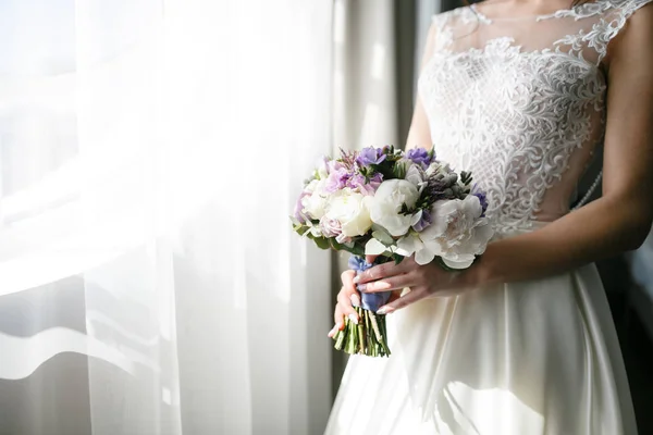 Bräute Brautstrauß mit Pfingstrosen, Freesien und anderen Blumen in Frauenhänden. helle und lila Frühlingsfarbe. Morgen im Zimmer — Stockfoto