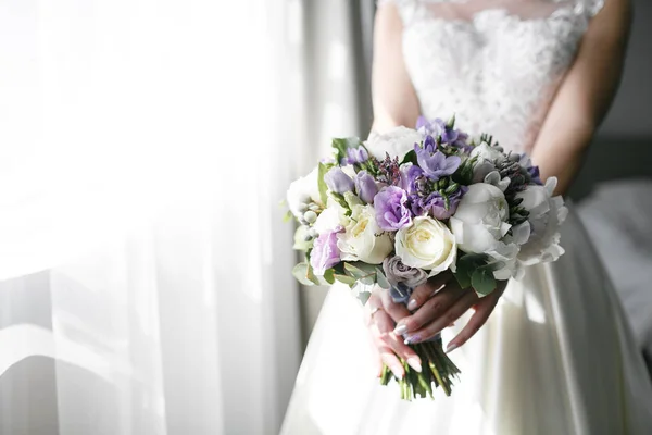 Bräute Brautstrauß mit Pfingstrosen, Freesien und anderen Blumen in Frauenhänden. helle und lila Frühlingsfarbe. Morgen im Zimmer — Stockfoto