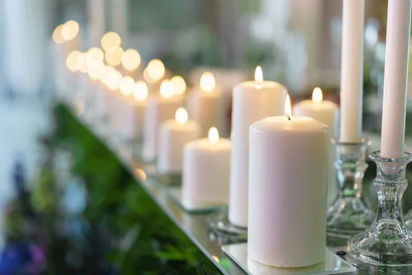 Palącej się świecy. Białe świece na świeczniki szkło stoisko na tabel na luksusowe wesele w restauracji. Stylowy wystrój i zdobiące — Zdjęcie stockowe
