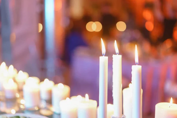 Καίγοντας κερί. Λευκά κεριά σε γυάλινα κηροπήγια περίπτερο σε τραπέζια σε πολυτελή δεξίωση στο εστιατόριο. κομψή διακόσμηση και στολίζουν — Φωτογραφία Αρχείου