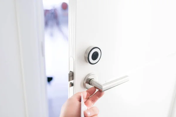 Otel kapı - bir anahtarın bir oda kapı Elektronik sensör önünde tutan genç adam. Kavram seyahat veya iş seyahati — Stok fotoğraf