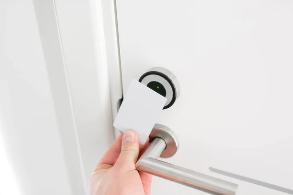 Porte de l'hôtel - Jeune homme tenant une carte-clé devant le capteur électronique d'une porte de chambre. Voyage concept ou voyage d'affaires — Photo