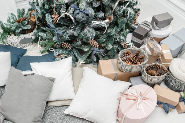 メリー クリスマスとハッピー ホリデー。クリスマスに飾られた美しいリビング ルーム。木製の素朴なデコレーションとロフトのインテリアでそれの下でプレゼントとクリスマス ツリー. — ストック写真