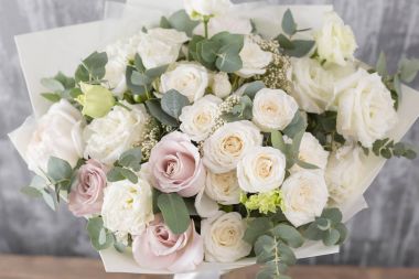 Yakın çekim güzel buket. Gri arka plan bahar çiçekleri. çiçekçi dükkanı. Ahşap masa