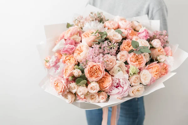 Boeket van mooie bloemen in womens handen. Bloemschikken concept. Lente kleuren. het werk van de bloemist op een bloemenwinkel. — Stockfoto