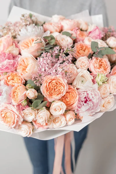 Boeket van mooie bloemen in womens handen. Bloemschikken concept. Lente kleuren. het werk van de bloemist op een bloemenwinkel. — Stockfoto