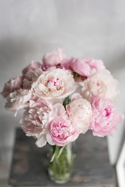 Bonita y encantadora peonía. muchos pétalos en capas. Ramo de flores de peonías de color rosa pálido fondo gris claro. Fondos de pantalla, Fotografía vertical — Foto de Stock