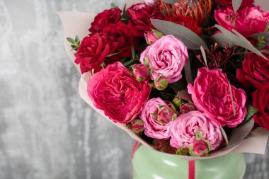 Yakın çekim güzel buket. Gri arka plan bahar çiçekleri. çiçekçi dükkanı. Ahşap masa