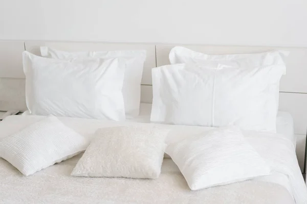 ベッドに快適な柔らかい枕。クローズ アップ ホワイトは光の壁の部屋の背景にシーツ、枕を寝具します。新鮮なベッドのコンセプト — ストック写真