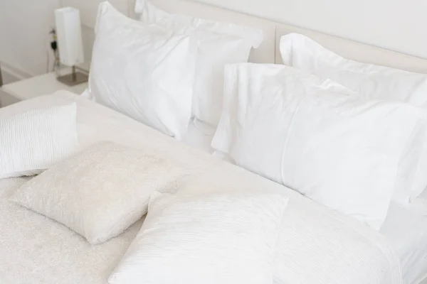 ベッドに快適な柔らかい枕。クローズ アップ ホワイトは光の壁の部屋の背景にシーツ、枕を寝具します。新鮮なベッドのコンセプト — ストック写真