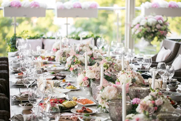 Garland van bloemen en groen voor tafeldecoratie. Luxe bruiloft receptie in restaurant. Stijlvolle inrichting en sieren. Tabellen geserveerd met mooie gerechten en heerlijk eten — Stockfoto