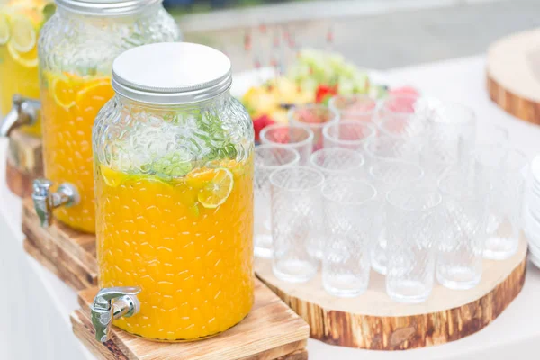 Banco de vidro de limonada com frutas cítricas fatiadas em uma mesa de buffet. Verão festa ao ar livre. Desintoxicação . — Fotografia de Stock