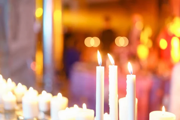 Καίγοντας κερί. Λευκά κεριά σε γυάλινα κηροπήγια περίπτερο σε τραπέζια σε πολυτελή δεξίωση στο εστιατόριο. κομψή διακόσμηση και στολίζουν — Φωτογραφία Αρχείου