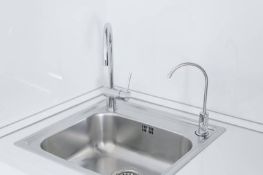 İki metal krom Lavabo Musluklar, düz ve su filtreli. Modern mutfak tezgah ve lavabo ile parçası. İç daire detay.