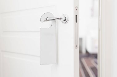 Metniniz için bir kapı kolu boş etiketi ile kapı kolu. Boş beyaz el ilanı mockup kapı kolu bekle. Broşür tasarımı üzerinde giriş kapı tokmağı. İşareti rahatsız etmeyin. Otel Oda açık askı. boş