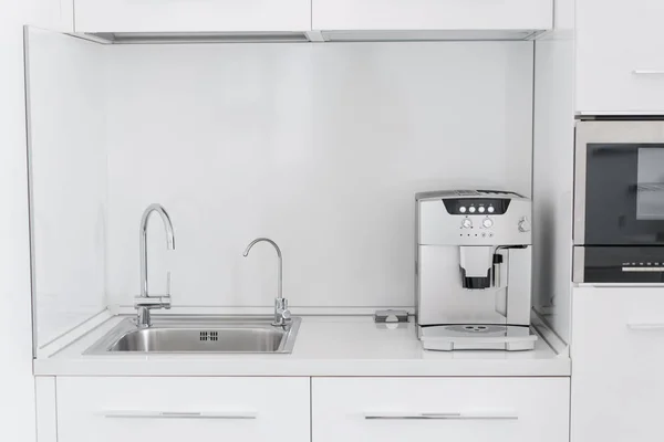 Металлическая хромированная раковина с двумя кранами, простой и фильтрованной водой. Фрагмент современной кухни со стойкой и раковиной. Интерьерная квартира . — стоковое фото