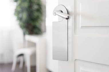 Metniniz için bir kapı kolu boş etiketi ile kapı kolu. Boş beyaz el ilanı mockup kapı kolu bekle. Broşür tasarımı üzerinde giriş kapı tokmağı. İşareti rahatsız etmeyin. Otel Oda açık askı. boş