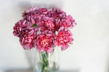 bir tabloda bir vazoda karanfil güzel çiçekler. Menekşe, mor ve pembe çok renkli çiçek buketi. Ev dekorasyon. Duvar kağıdı ve arka plan. Dikey fotoğraf