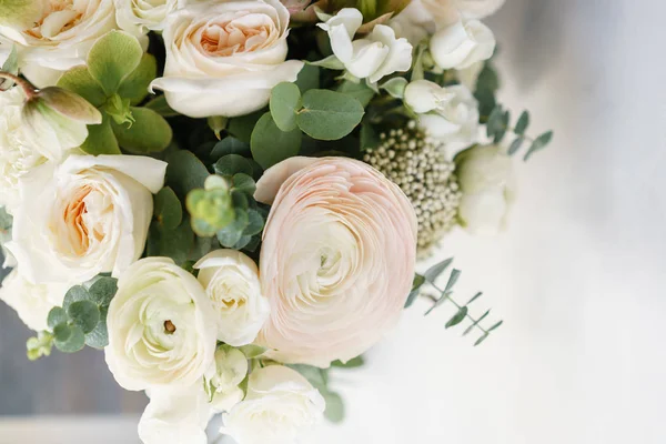 Bouquet de mariage de roses blanches et buttercup sur une table en bois. Beaucoup de verdure, moderne asymétrique nuptiale échevelée — Photo