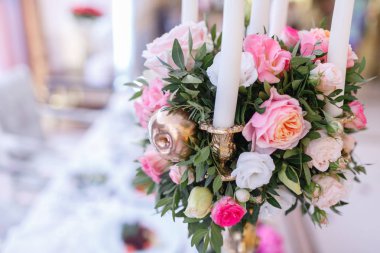 Metal sarısı avize üzerine beyaz mumlar restorandaki lüks düğün resepsiyonunda masaların üzerinde duruyor. şık dekorasyon ve süslemeler.