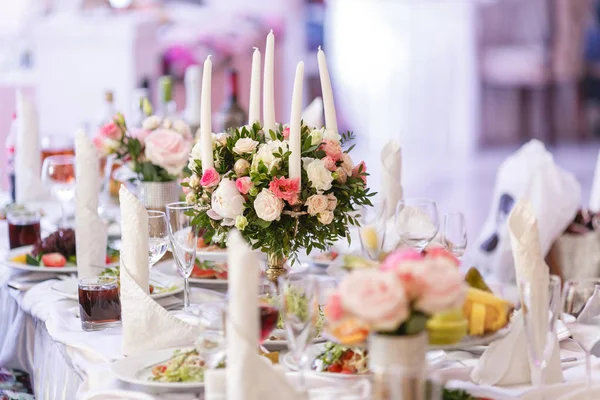 Le candele bianche su lampadario d'oro in metallo stanno su tavoli all'atto di ricevimento nuziale di lusso in ristorante. arredamento elegante e ornamento — Foto Stock