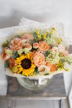 Ayçiçeği gri tablo ile güzel çiçekler buket. Floristik kavramı. Bahar renkleri. Çiçekçi Çiçek dükkanında çalışır. Dikey fotoğraf