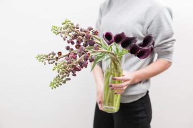 Güzel mor-kahverengi Fritillaria çiçek ve Calla buket. Kadın el bahar çiçeklenir. Çiçekçi Çiçek dükkanında çalışır. Yatay fotoğraf