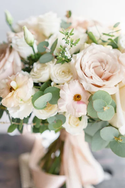 Hochzeitsstrauß aus weißen Rosen und Butterblume auf einem Holztisch. Viel Grün, moderner asymmetrisch zerzauster Brautstrauß — Stockfoto