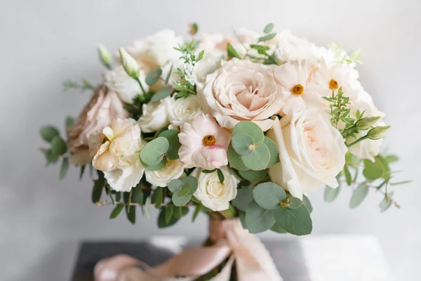 Hochzeitsstrauß aus weißen Rosen und Butterblume auf einem Holztisch. Viel Grün, moderner asymmetrisch zerzauster Brautstrauß — Stockfoto