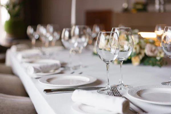 Mesa en el restaurante, vasos en primer plano. Recepción de boda de lujo. Arreglo floral en la mesa en el restaurante. Decoración elegante y adorno . — Foto de Stock