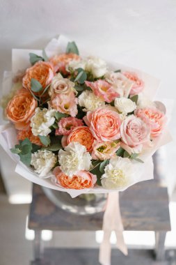 pastel turuncu ve Pembe buket güzel ahşap masa üzerinde. Floristik kavramı. Bahar renkleri. Çiçekçi Çiçek dükkanında çalışır. Dikey fotoğraf