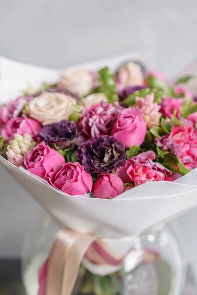 Фиолетовый и розовый букет красивых цветов на деревянном столе. Концепция флористики. Весенние цвета. работа флориста в цветочном магазине. Вертикальное фото — стоковое фото