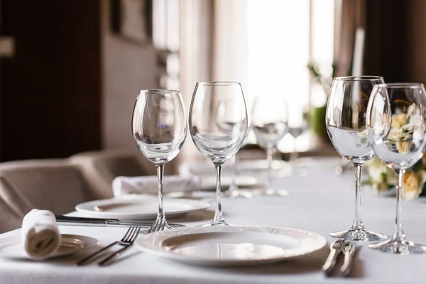 Mesa en el restaurante, vasos en primer plano. Recepción de boda de lujo. Arreglo floral en la mesa en el restaurante. Decoración elegante y adorno . — Foto de Stock