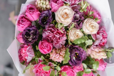 Renkli bahar renkleri. Çiçekçi Çiçek dükkanında çalışır. Ahşap masa üzerine güzel çiçekler mor ve Pembe buket.