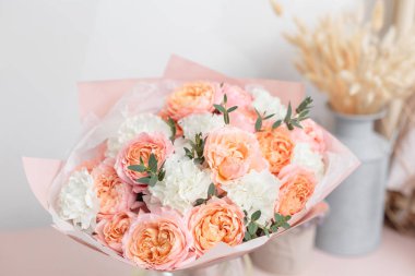 pastel turuncu ve Pembe buket güzel ahşap masa üzerinde. Floristik kavramı. Bahar renkleri. Çiçekçi Çiçek dükkanında çalışır. Dikey fotoğraf