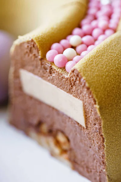 Lujoso postre redondo con esferas de chocolate rosa. Tarta de cumpleaños mousse amarilla con bolas de azúcar dulces multicolores. Patrón de bolas pequeñas . — Foto de Stock