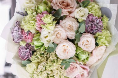 çiçek aranjmanı. ahşap masa üzerine güzel çiçekler çok renkli buket. Floristik kavramı. Bahar renkleri. Dikey fotoğraf