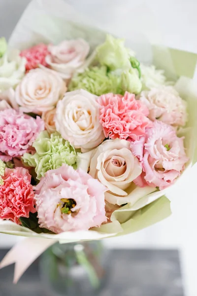 Flower arrangement. multicolor bouquet of beautiful flowers on wooden table. Floristry concept. Spring colors. Vertical photo — Stock Photo, Image