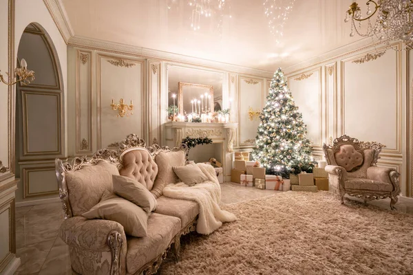 Heiligabend im Schein von Kerzen und Girlanden. klassische luxuriöse Apartments mit geschmücktem Weihnachtsbaum und Geschenken. Wohnen mit Kamin, Säulen und Stuck. — Stockfoto