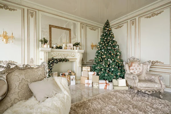 Mañana de Navidad. Apartamentos de lujo clásicos con árbol de Navidad decorado y regalos. Vivir con chimenea, columnas y estuco . — Foto de Stock