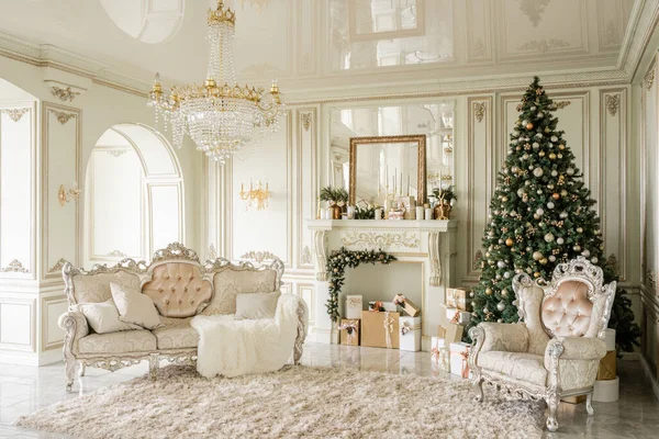 Mañana de Navidad. Apartamentos de lujo clásicos con árbol de Navidad decorado y regalos. Vivir con chimenea, columnas y estuco . — Foto de Stock